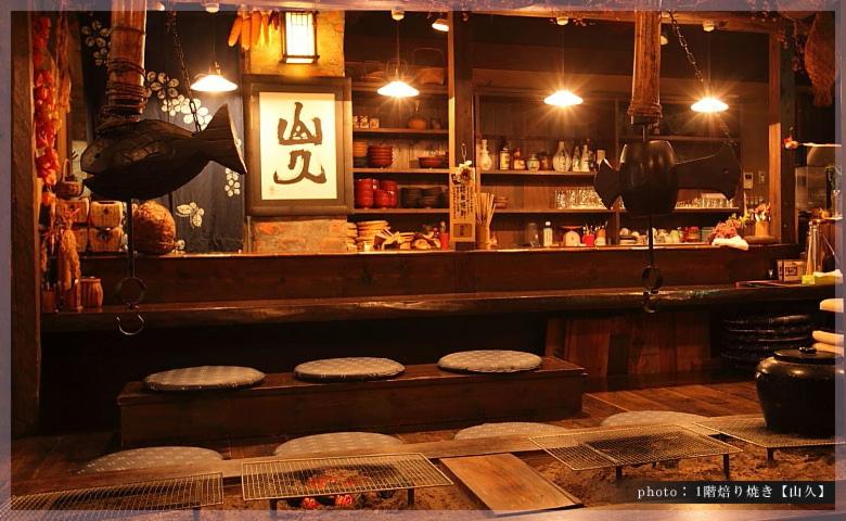a bar with two stools in front of a counter at Ryokan Yamanoyu in Minamioguni