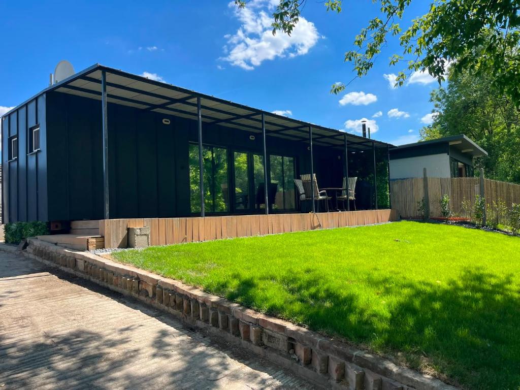 a black house with a lawn in front of it at MAX Dunaj in Trstice