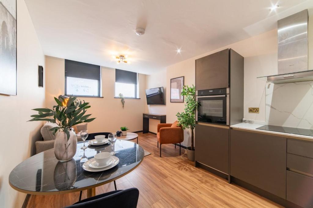 a living room with a table and a kitchen at LS1 - Luxury City Centre Apartments Leeds in Leeds