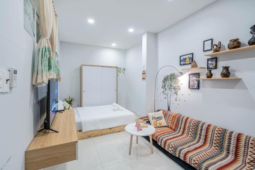 a living room with a couch and a bed at LalaHouse Pasteur in Ho Chi Minh City
