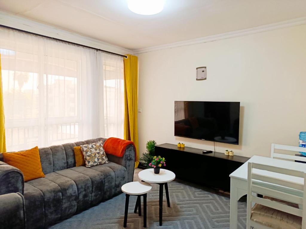 a living room with a couch and a flat screen tv at Mura suites homes in Nakuru