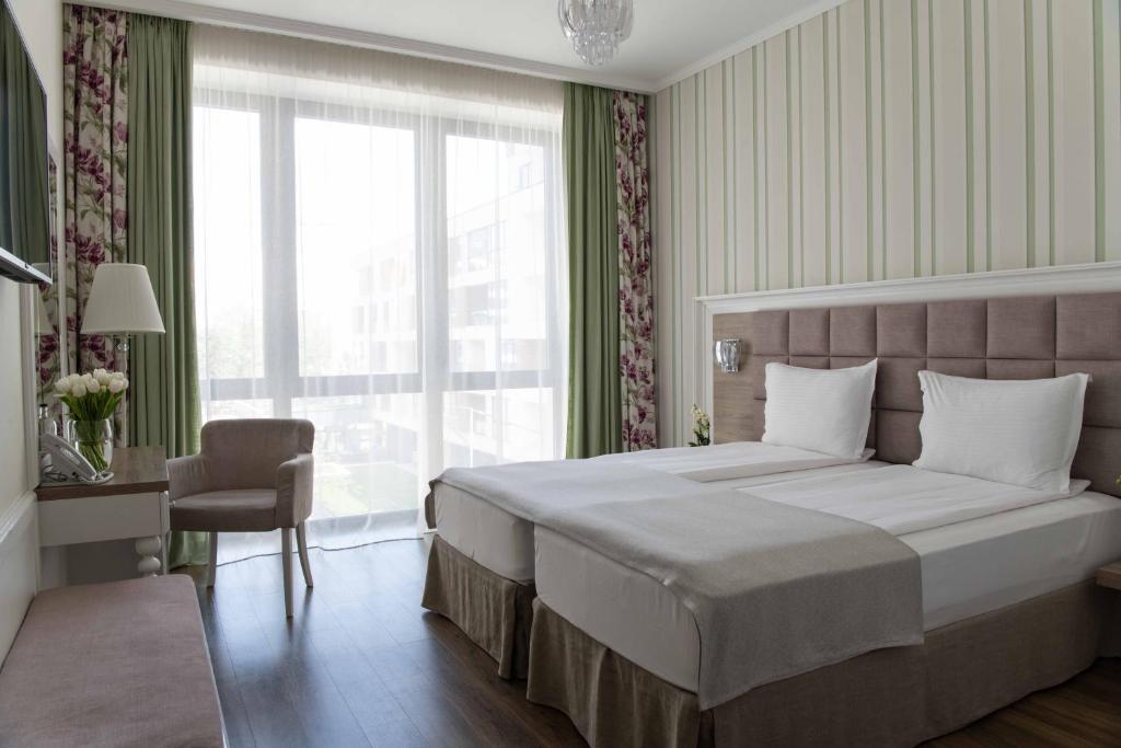 a bedroom with a large bed and a large window at Impresamente Art Hotel in Sofia
