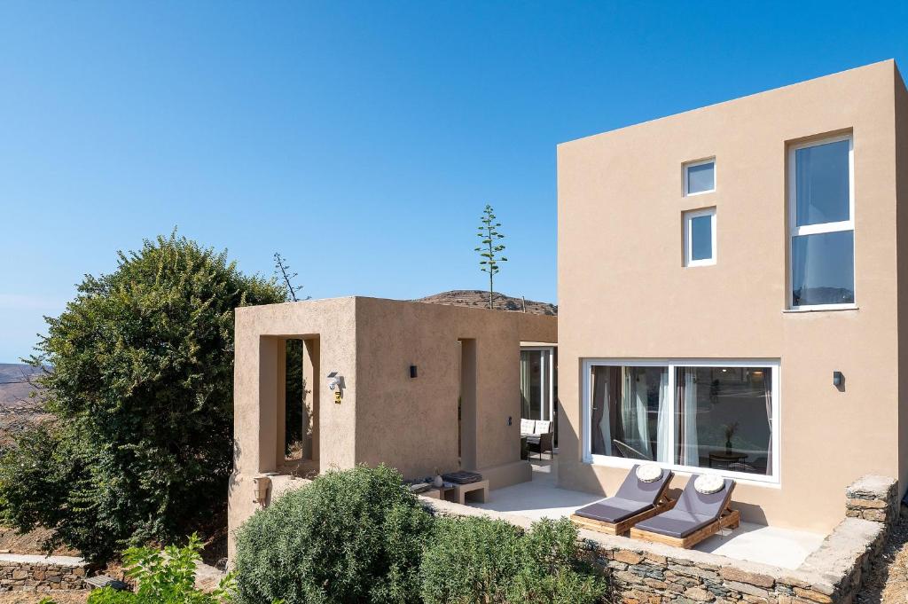 a house in the desert with two chairs at The Aer Element Of Gaea in Loutrá