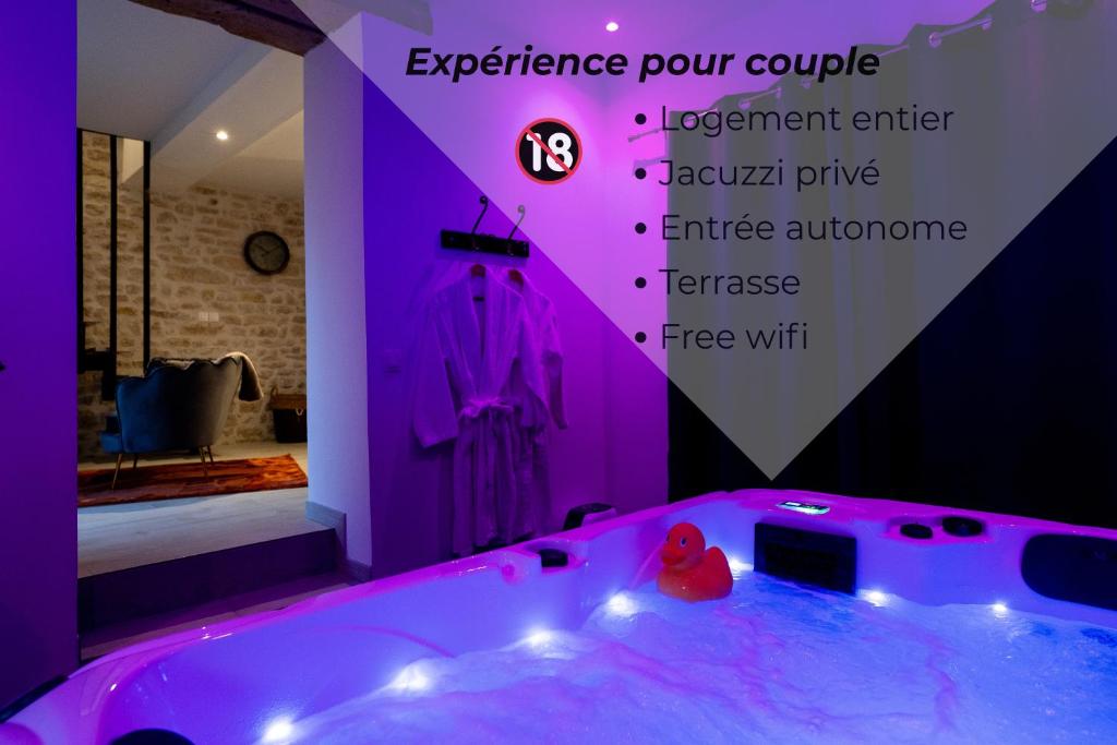 a bathroom with a tub with purple lighting at Jacuzzi privé Love Room Entre Nemours et Montargis in Château-Landon