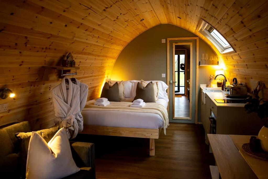 a bedroom with a large bed in a wooden room at The Fox at Snowhill Glamping in Scorton