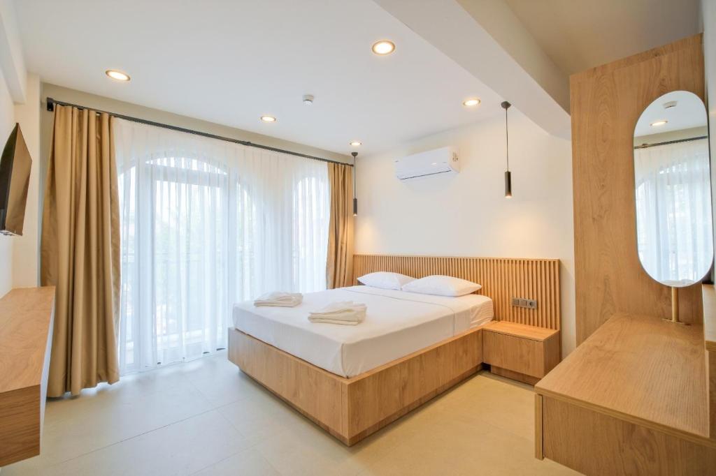 a bedroom with a bed and a large window at Miralya Downtown in Fethiye