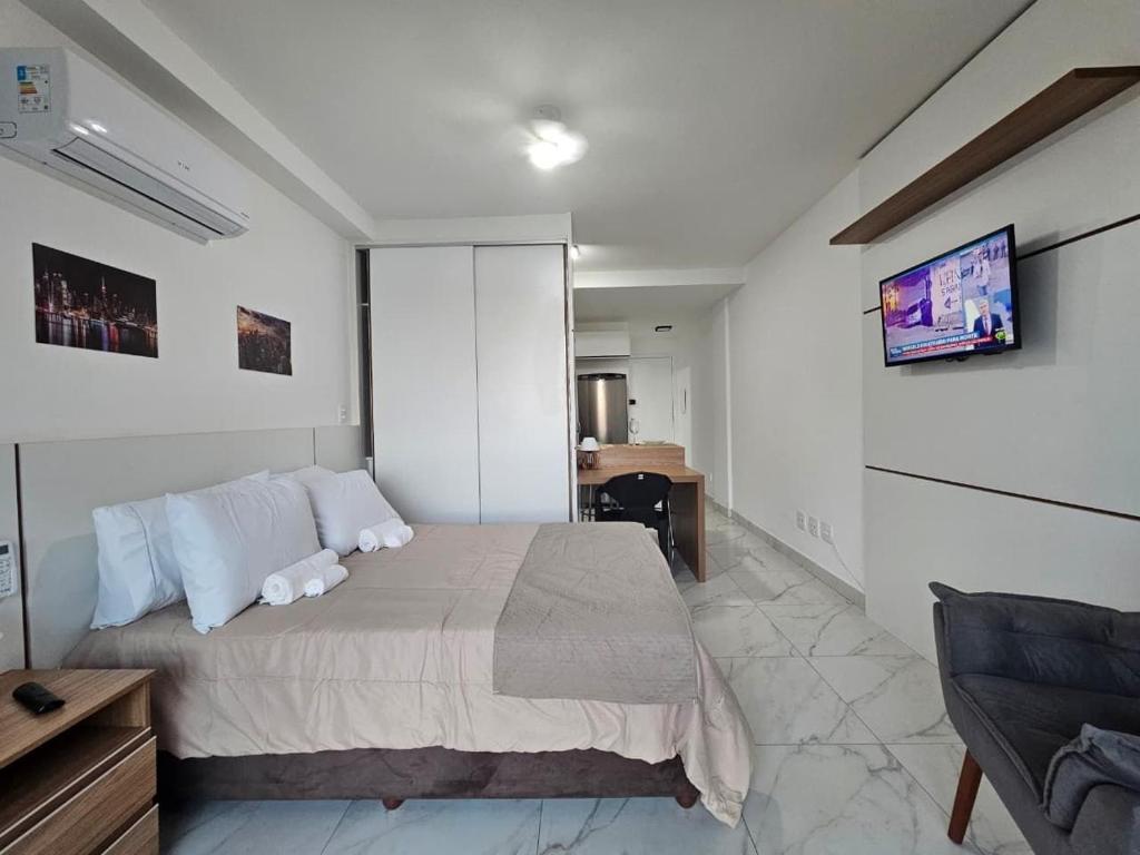 a bedroom with a bed and a desk at Studio moderno no centro próximo a Academia e Cave in Juiz de Fora