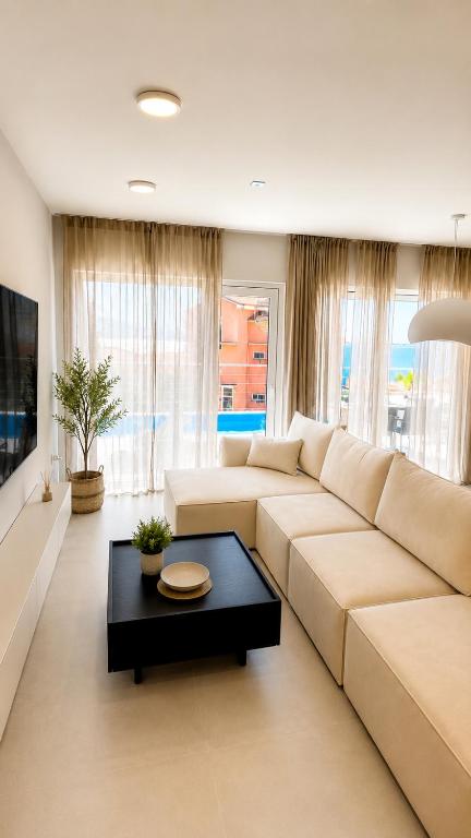 a living room with a white couch and a table at Apartments Villa Klaudia in Crikvenica