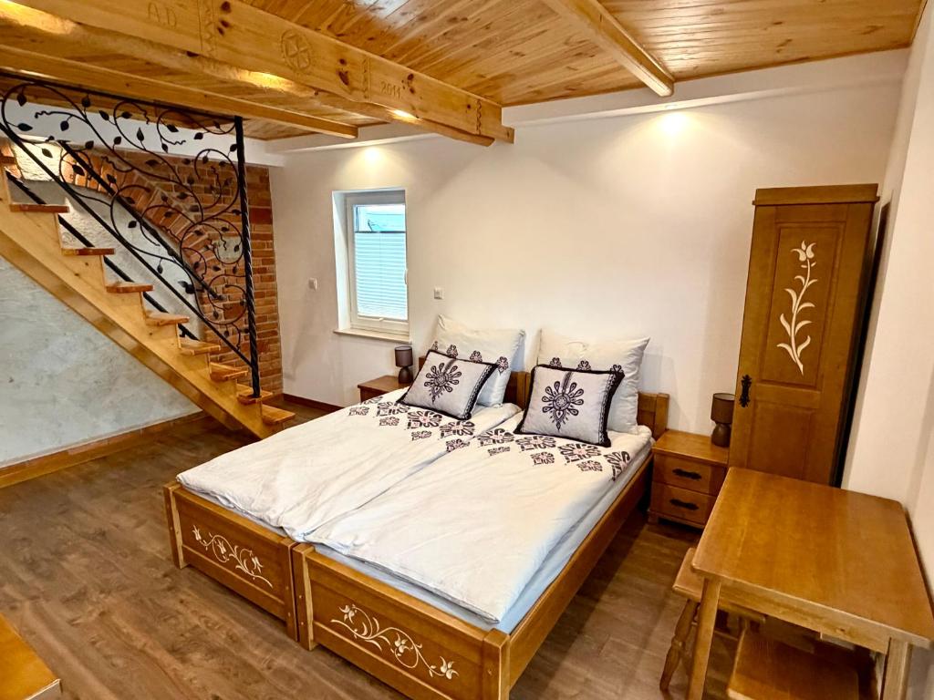 a bedroom with a bed and a staircase at Gorczański Wierch in Maniowy