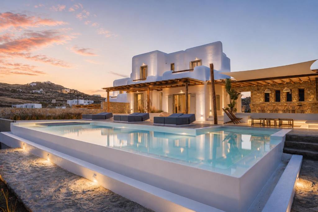 a swimming pool in front of a house at Villa Yasemin - Mykonos Paradise - Views - Pool - Large Garden in Kalafatis