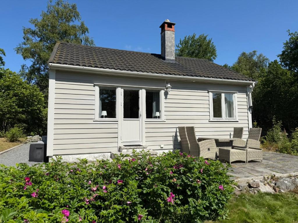 a white house with two chairs in front of it at Charming sea view in Bergen