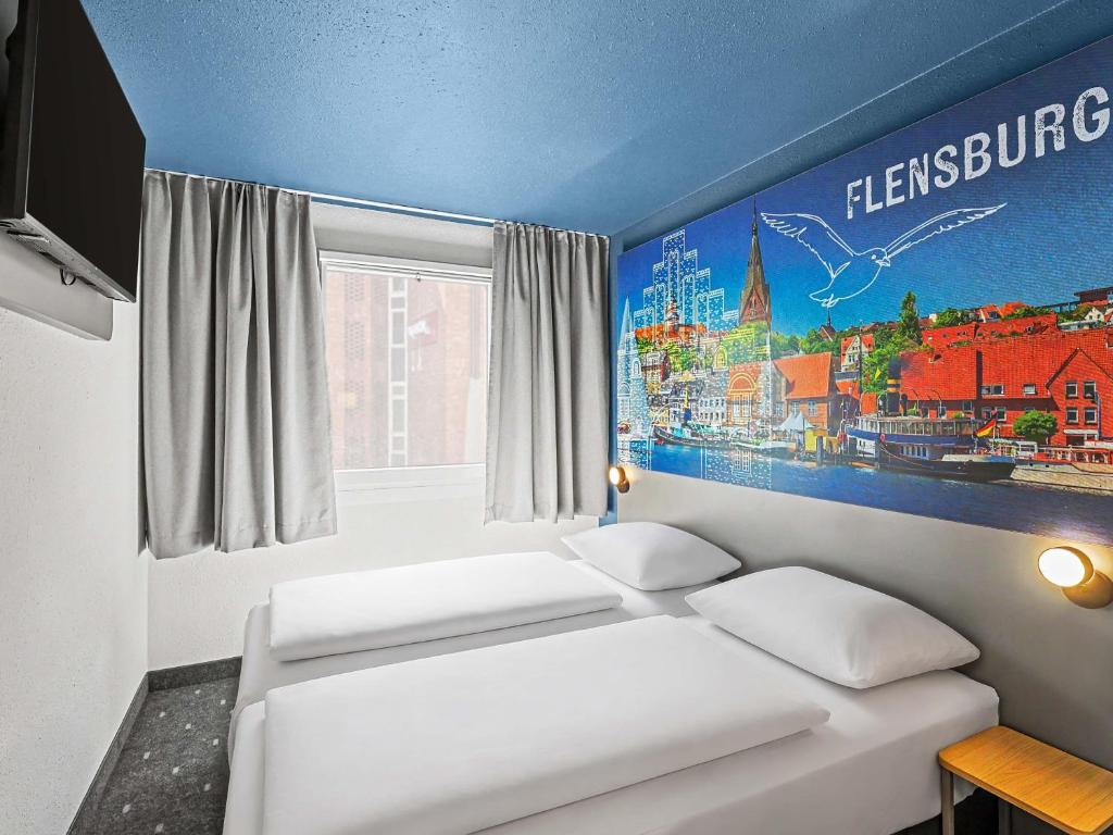 a bedroom with two beds and a poster on the wall at B&B HOTEL Flensburg-City in Flensburg