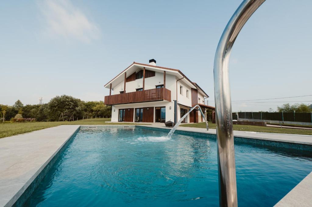 a pool with a water fountain in front of a house at Hotel Gamongoa in Rentería