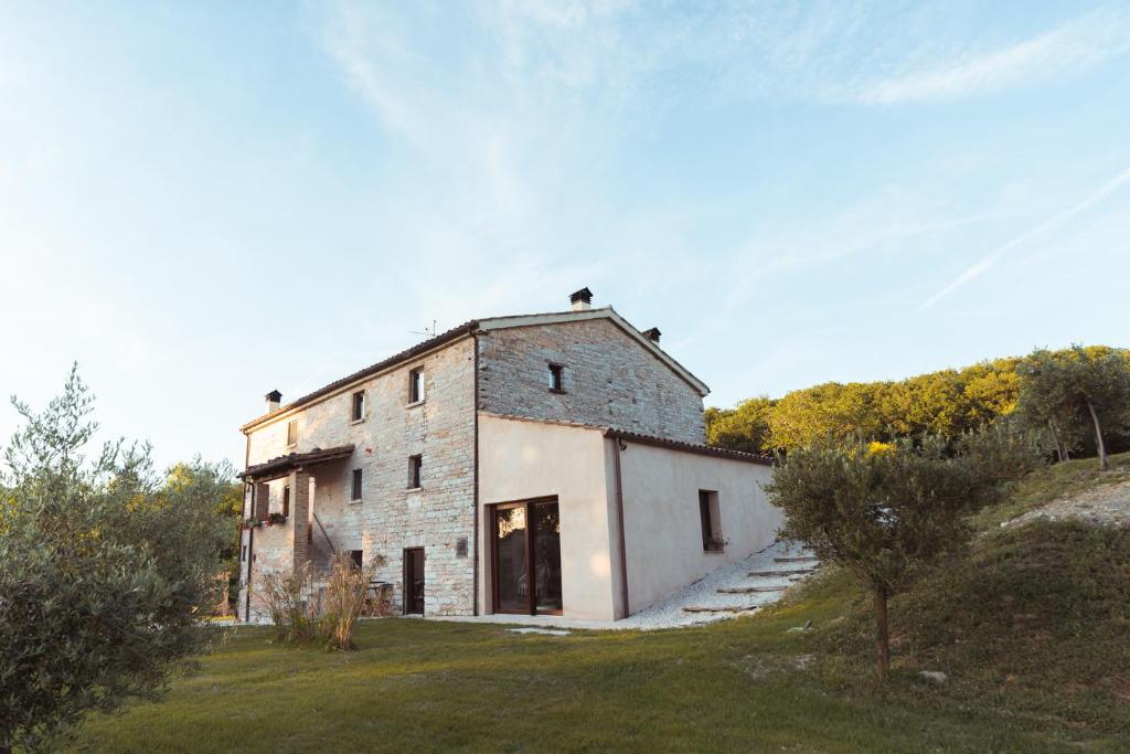 an old stone building with a door in a field at Tenuta del Picchio in Colombara