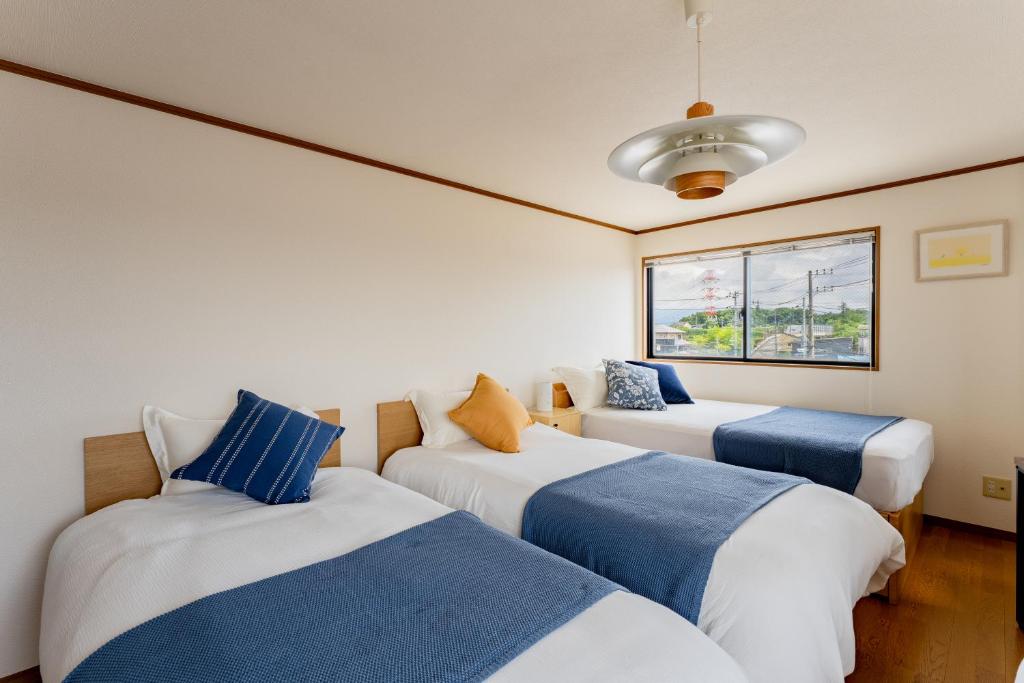 a room with two beds and a couch at DAI HOSTEL Ayase in Fukaya