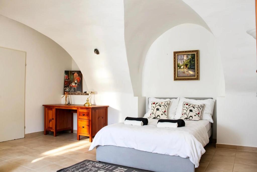 a bedroom with a bed and a wooden desk at Historic Flat & Private Courtyard in Bruck an der Leitha