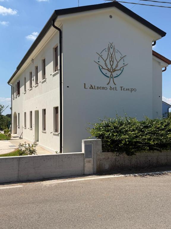 a white building with a sign on the side of it at L'Albero del Tempo in Falze