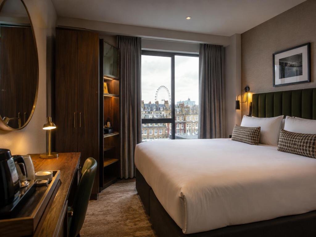 a hotel room with a large bed and a window at Metropole Hotel in London