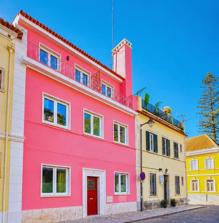 a pink building in a street with other buildings at Happy Sintra Inn Guesthouse & Breakfast in Sintra
