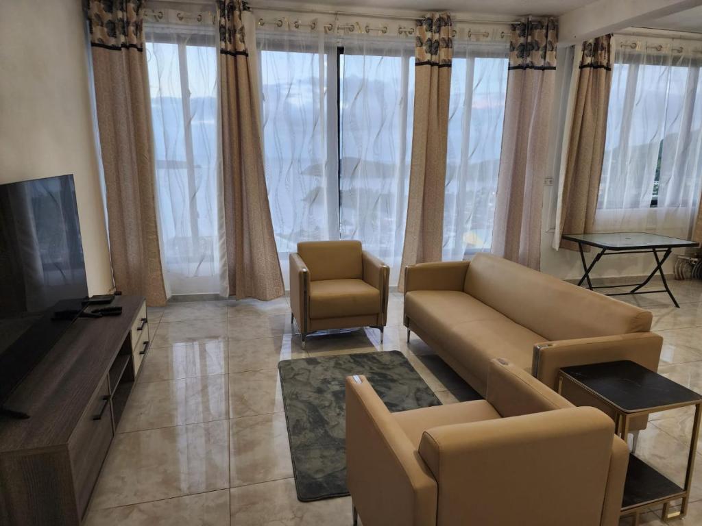 a living room with a couch and a tv at Entre Ciel et Lagon in Mtsamboro