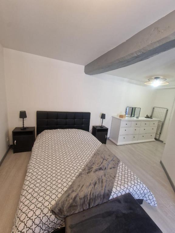 ein Schlafzimmer mit einem großen Bett und einer Kommode in der Unterkunft Zéline in Montholon