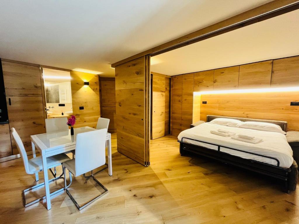 a bedroom with a bed and a desk and a table at GuestHost - Mulino del Bianco - Comfy Studio-Flat in La Thuile