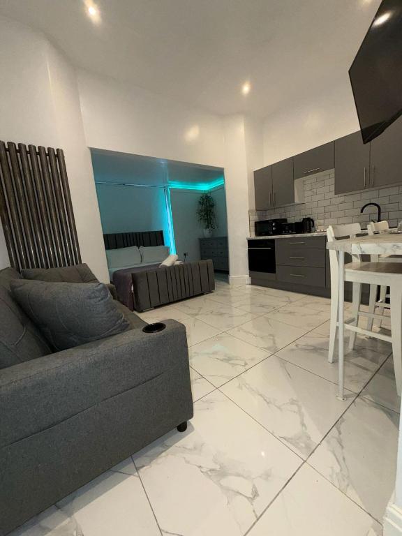 a living room with a couch and a table and a kitchen at Alexander's luxury rooms all en-suite, spa bath in Blackpool