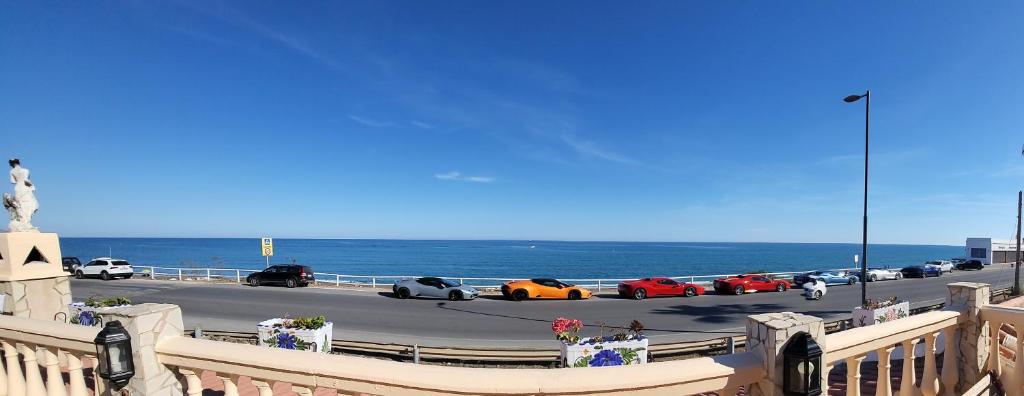 a group of cars parked on a highway next to the ocean at La Casita del Mar in Torrox