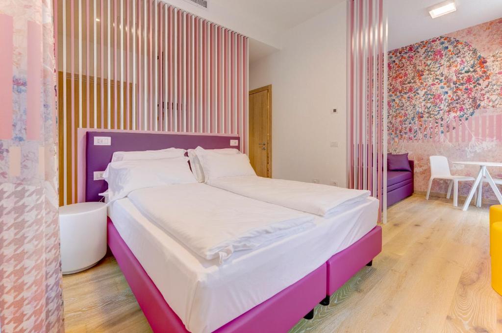 a bedroom with a large bed with a purple headboard at Holiday IV Gardan in Riva del Garda