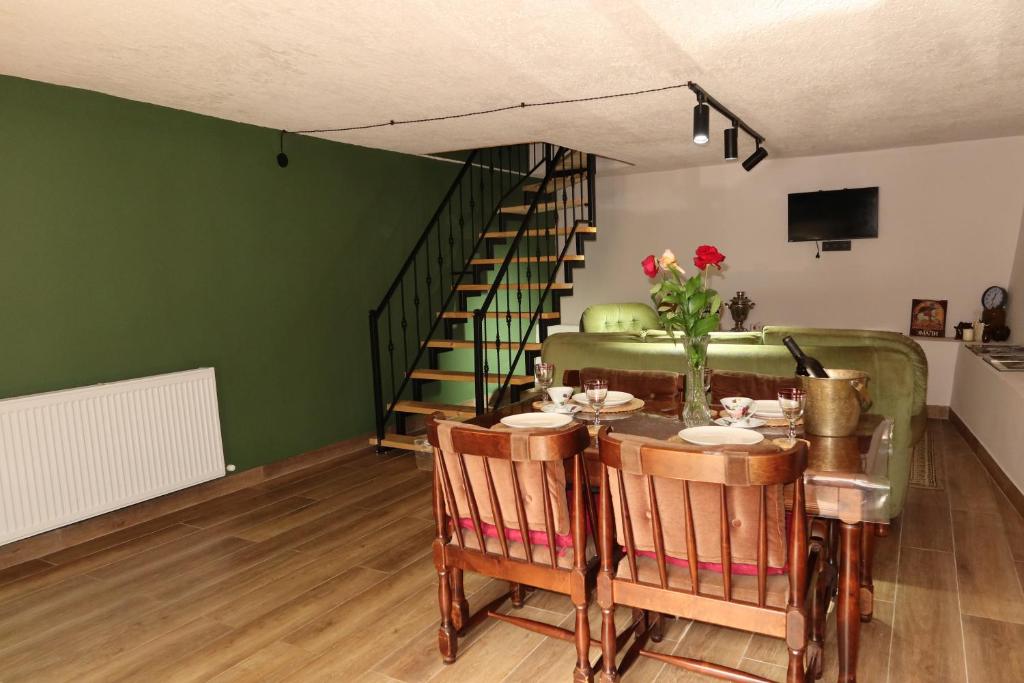 a dining room with a table and a couch at The Fireplace ROOM in Borjomi