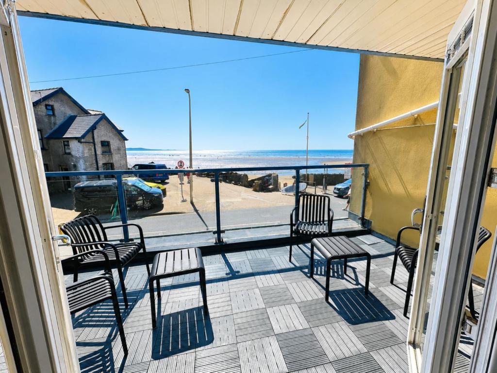 a balcony with chairs and a view of the ocean at Dog friendly sea front apartment with balcony in Pendine