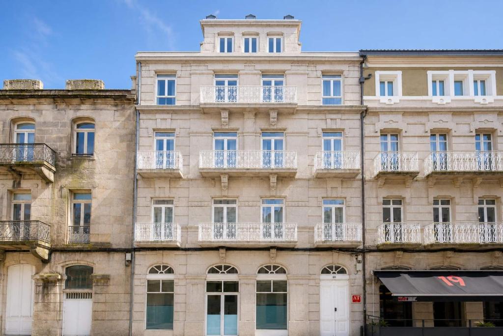 a large stone building with windows and balconies at YBH Mare Boutique in Vigo