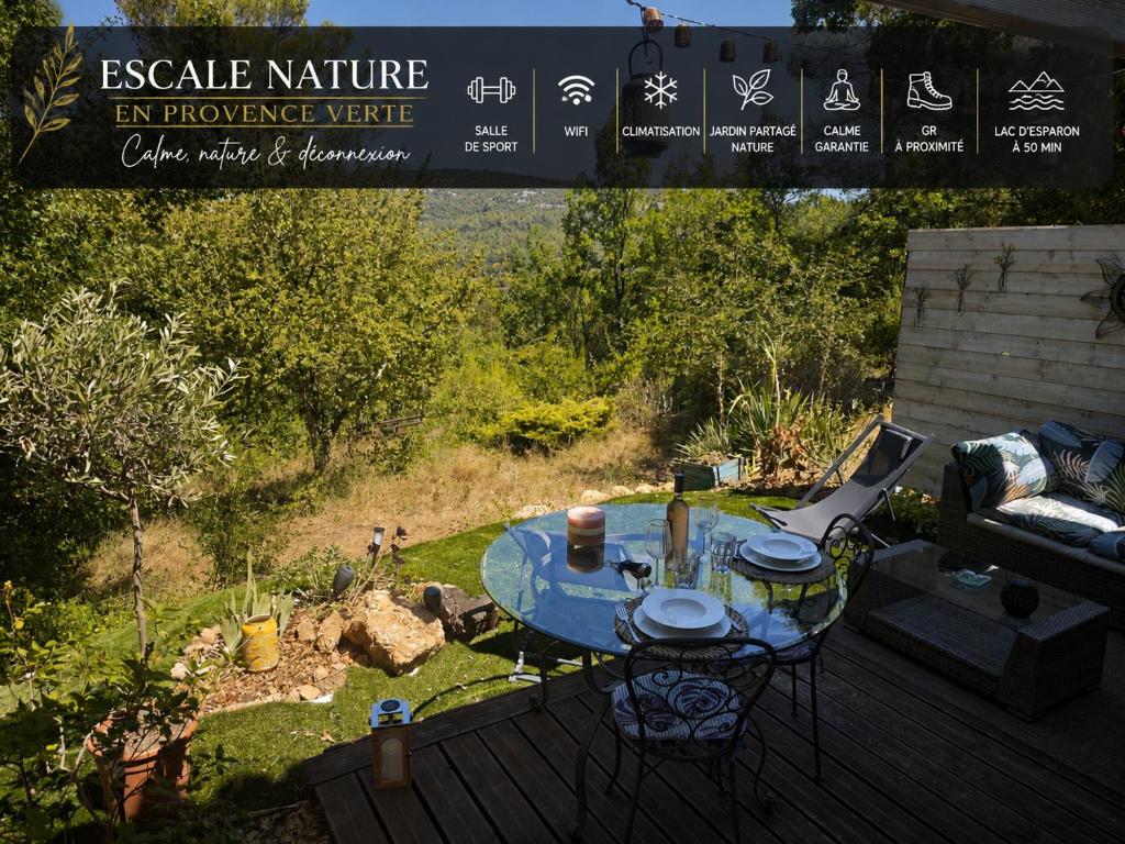 a table and chairs on a deck with a sign at Nature stopover in green Provence in Artigues