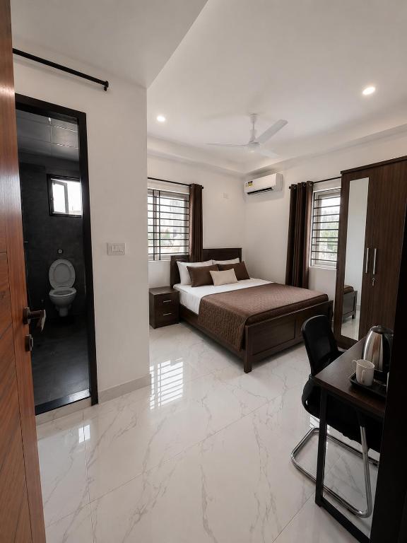 a bedroom with a bed and a desk and a chair at Mahankali Guest House in Hyderabad