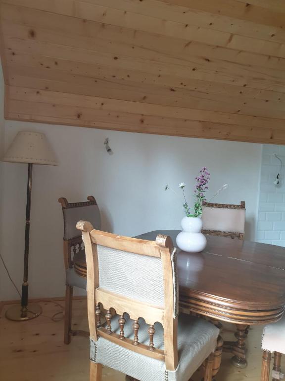 a dining room table and chairs with a wooden ceiling at VIG 2 in Njegovuđa