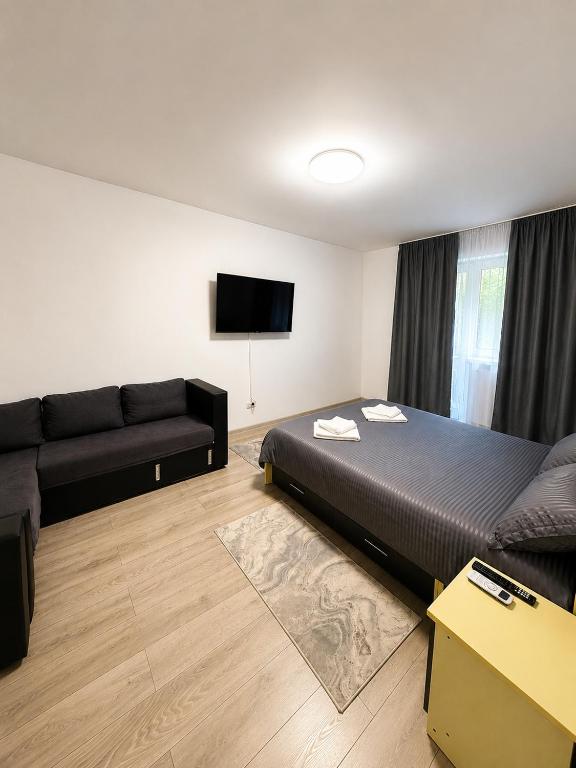a hotel room with a bed and a couch at Dobroesti Relax Apart in Dobroeşti