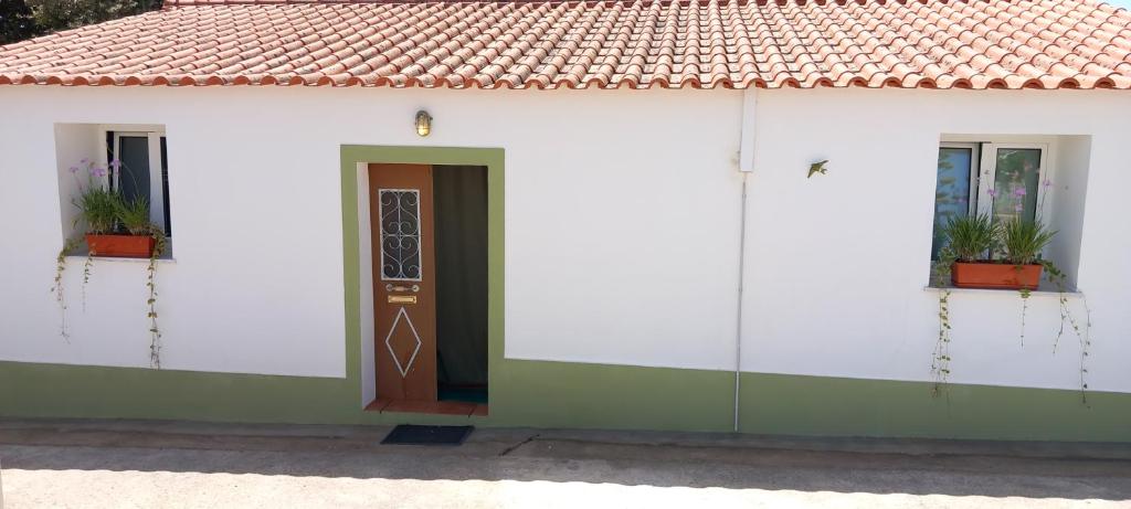 a white building with a door and a red roof at Casa Dominique in São Pedro do Corval