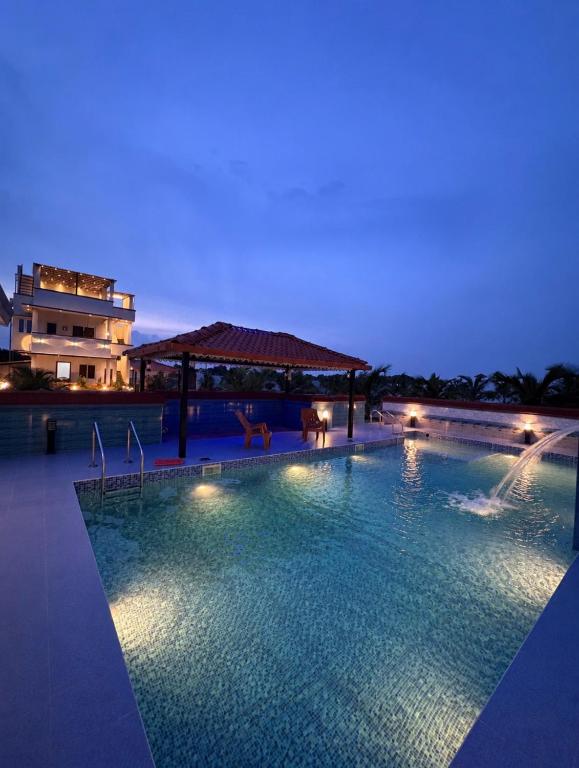 a large swimming pool at night with a building at Ocean Kala Crest in Cheyūr