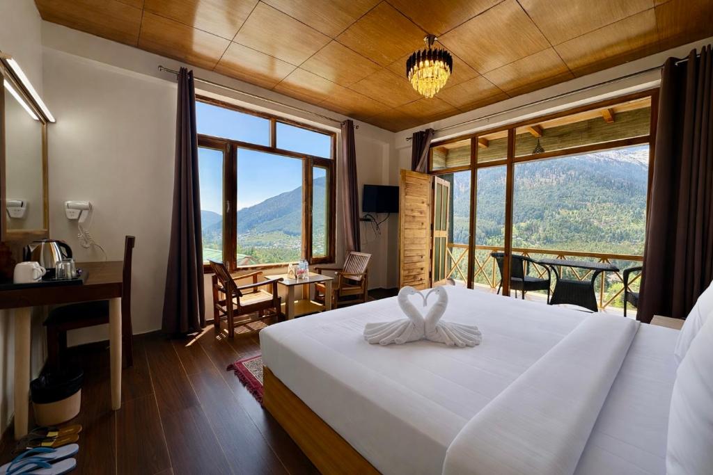 a bedroom with a bed with a view of a mountain at Hotel Naina Rockland , Manali in Vashisht