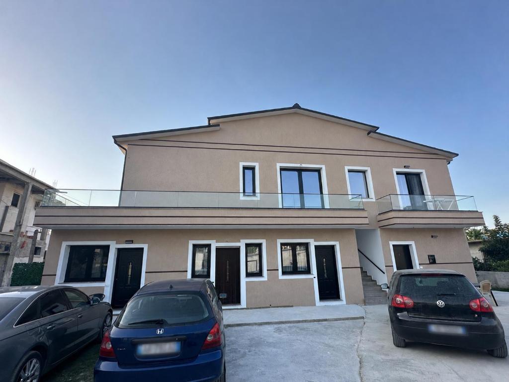 a house with two cars parked in front of it at Arval Rooms in Vlorë