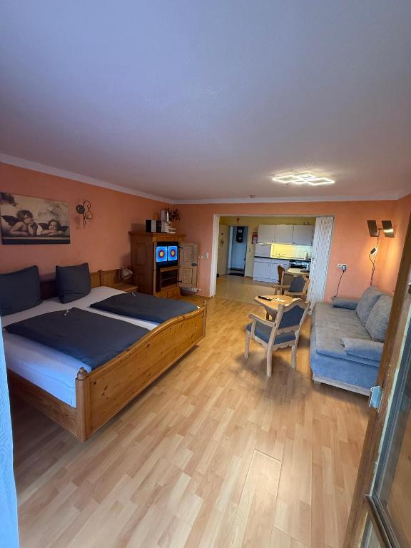 a bedroom with a large bed and a couch at Haus Hönigsgrub in Rinchnach