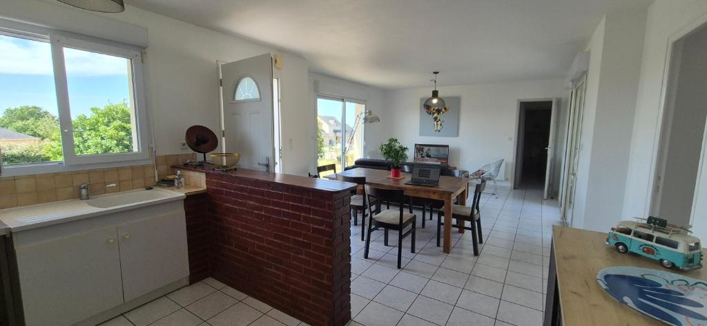 a kitchen with a table and a dining room at Gîte la Blanchère in Saint-Herblon