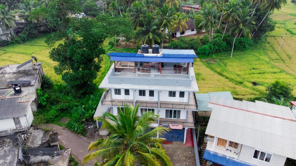 an overhead view of a house with a blue roof at Rainforest White House in Deniyaya