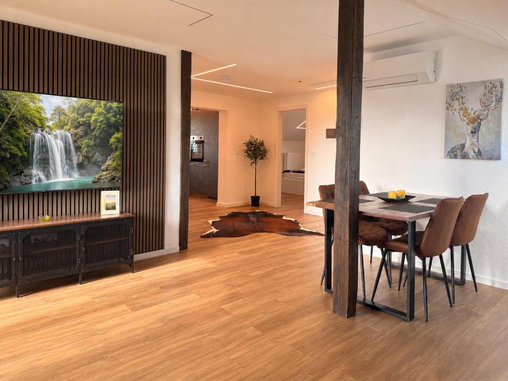 a dining room with a tv and a table with chairs at Apartment 98 - 2 Schlafzimmer, Balkon & Vogelsbergblick in Hungen