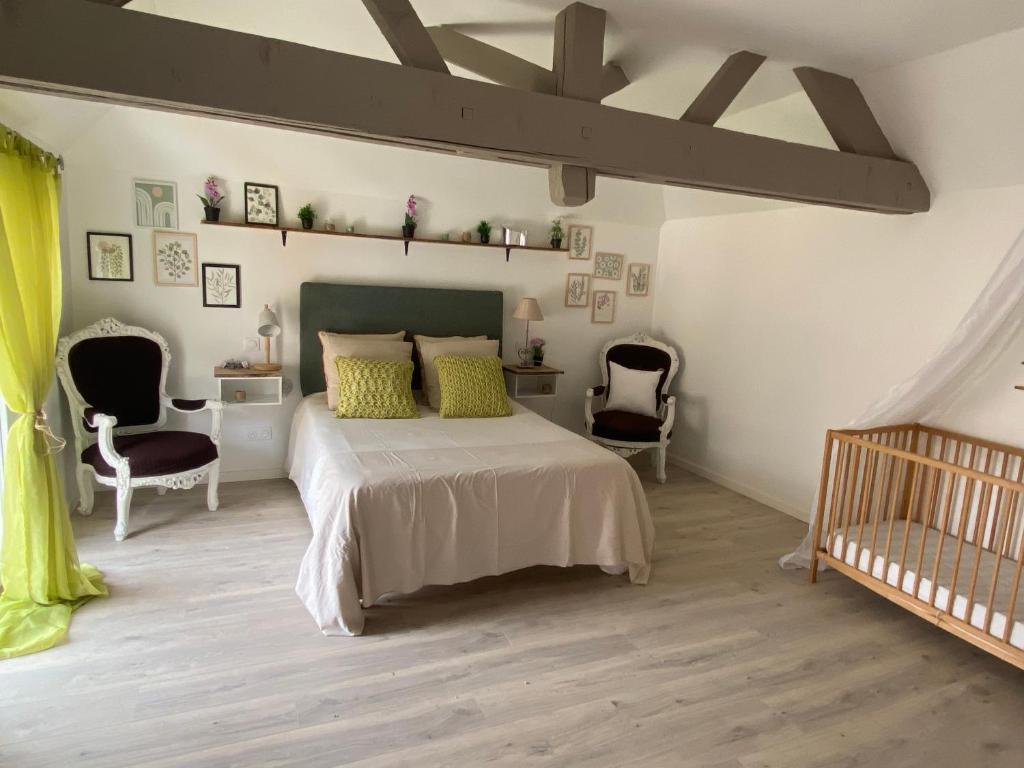 a bedroom with a bed and two chairs and a crib at Lys in Gury