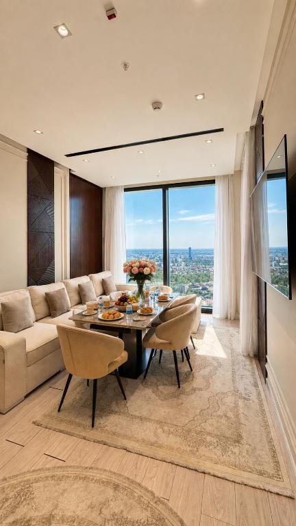 a living room with a couch and a table and chairs at NestOne Apartment 39th floor in Tashkent