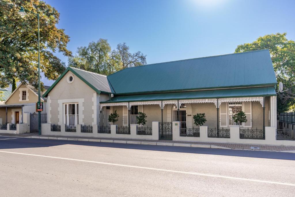 a building with a green roof on a street at Elizabeth's Cottage in Montagu