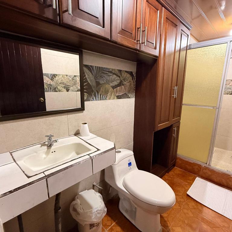 a bathroom with a white toilet and a sink at Villa Gonz in Río Cuarto