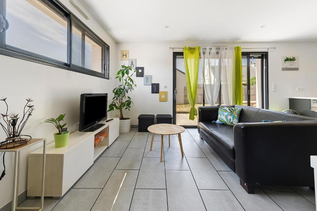 a living room with a couch and a tv at Maison La Plouhinecoise in Plouhinec