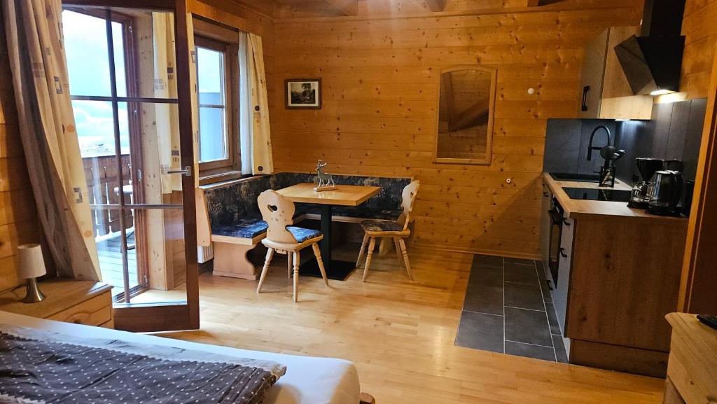 a kitchen with a table and chairs in a room at Appartement Gugganig in Flattach